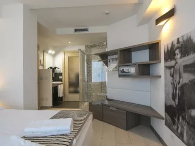 Nowoczesny pokój hotelowy z łóżkiem, łazienką i designerskimi meblami. Bezpieczny sejf.