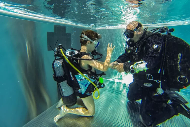 Instruktor nurkowania uczy chłopca pod wodą. Nauka nurkowania, kurs nurkowania, podwodna przygoda.