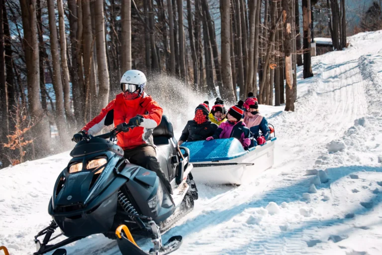 Zimowa przejażdżka skuterem śnieżnym z pasażerami w przyczepie. Przygoda na śniegu!