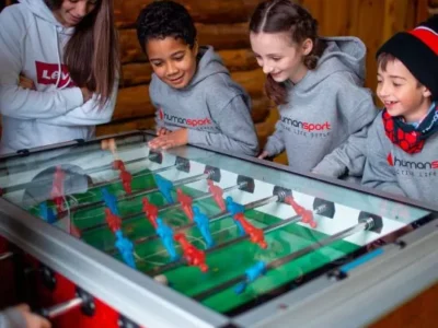 Dzieci grają w piłkarzyki. Radość i rywalizacja przy stole do gry.