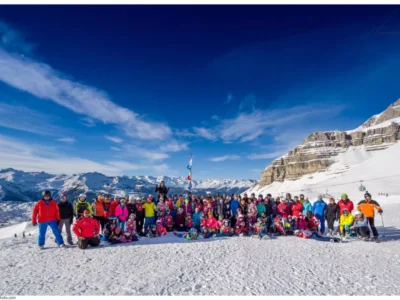 Duża grupa narciarzy i snowboardzistów na tle gór. Zimowy krajobraz.