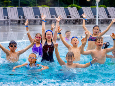 Dzieci w trakcie nauki pływania w basenie.