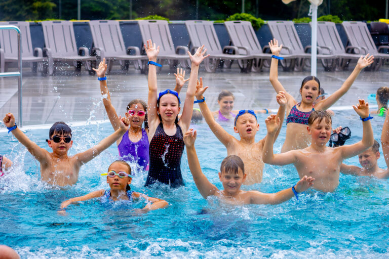 Dzieci w trakcie nauki pływania w basenie.