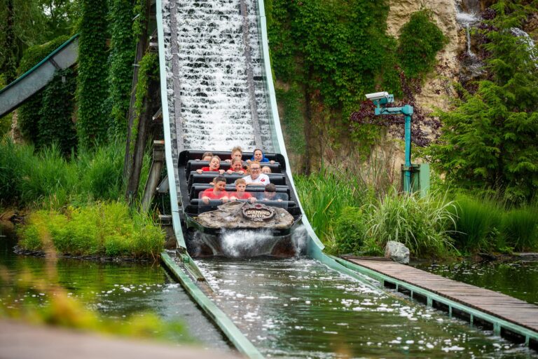 Rodzina na zjeżdżalni wodnej w parku rozrywki. Radość i zabawa!
