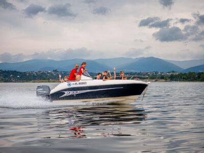 Rodzina na łodzi motorowej, wodna przygoda, wakacje nad jeziorem, zabawa na wodzie.