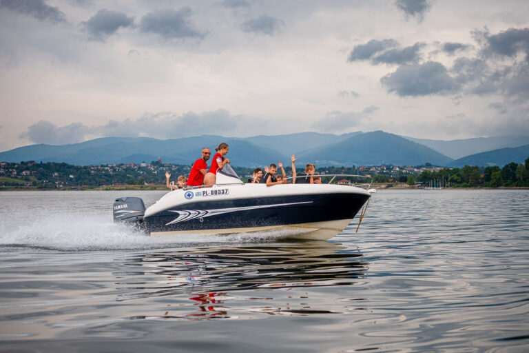 Rodzina na łodzi motorowej, wodna przygoda, wakacje nad jeziorem, zabawa na wodzie.