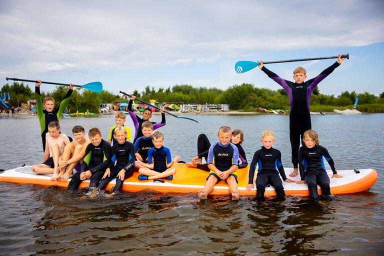 Dzieci na desce SUP, zabawa na wodzie, lato, sport, aktywność.