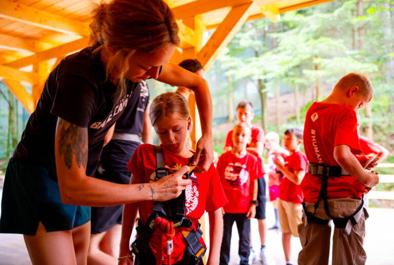 Dzieci w czerwonych koszulkach przygotowują się do przygody. Bezpieczeństwo przede wszystkim!