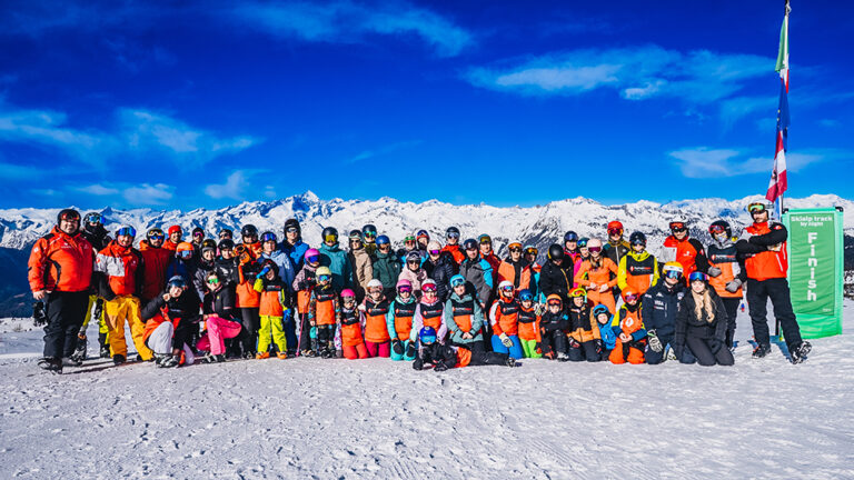 Grupa narciarzy i snowboardzistów na tle gór. Zima, sport, rodzina.