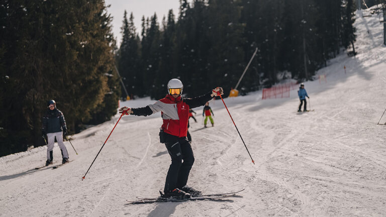 Instruktor narciarstwa uczy dzieci na stoku. Narty, śnieg, zimowy sport.