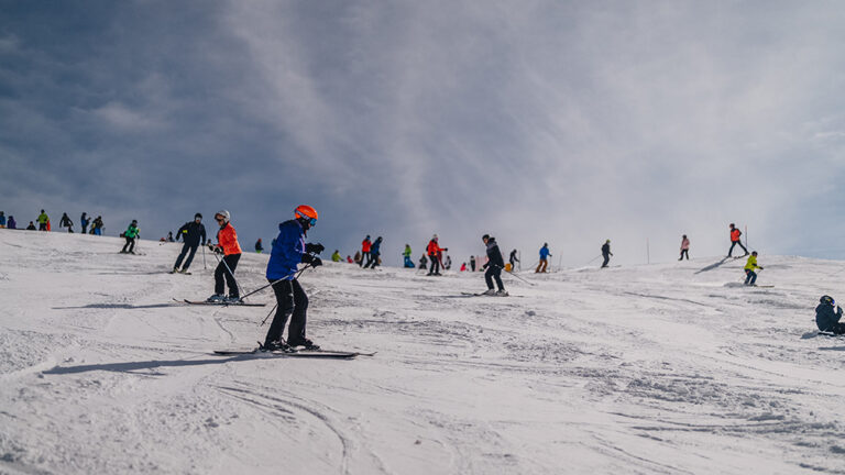 Narciarze na ośnieżonym stoku. Zimowy sport i rekreacja na nartach.