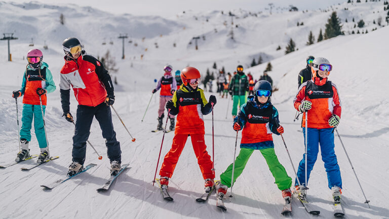 Dzieci na nartach w Alpach. Nauka jazdy na nartach dla najmłodszych. Zimowy sport.