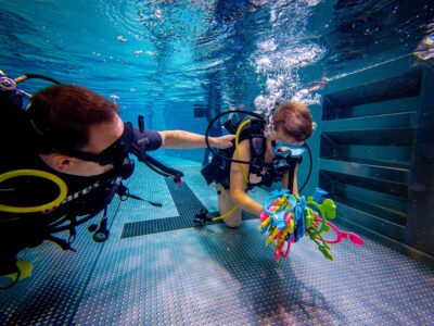 Podwodna nauka nurkowania dla dzieci. Kolorowe zabawki pod wodą.